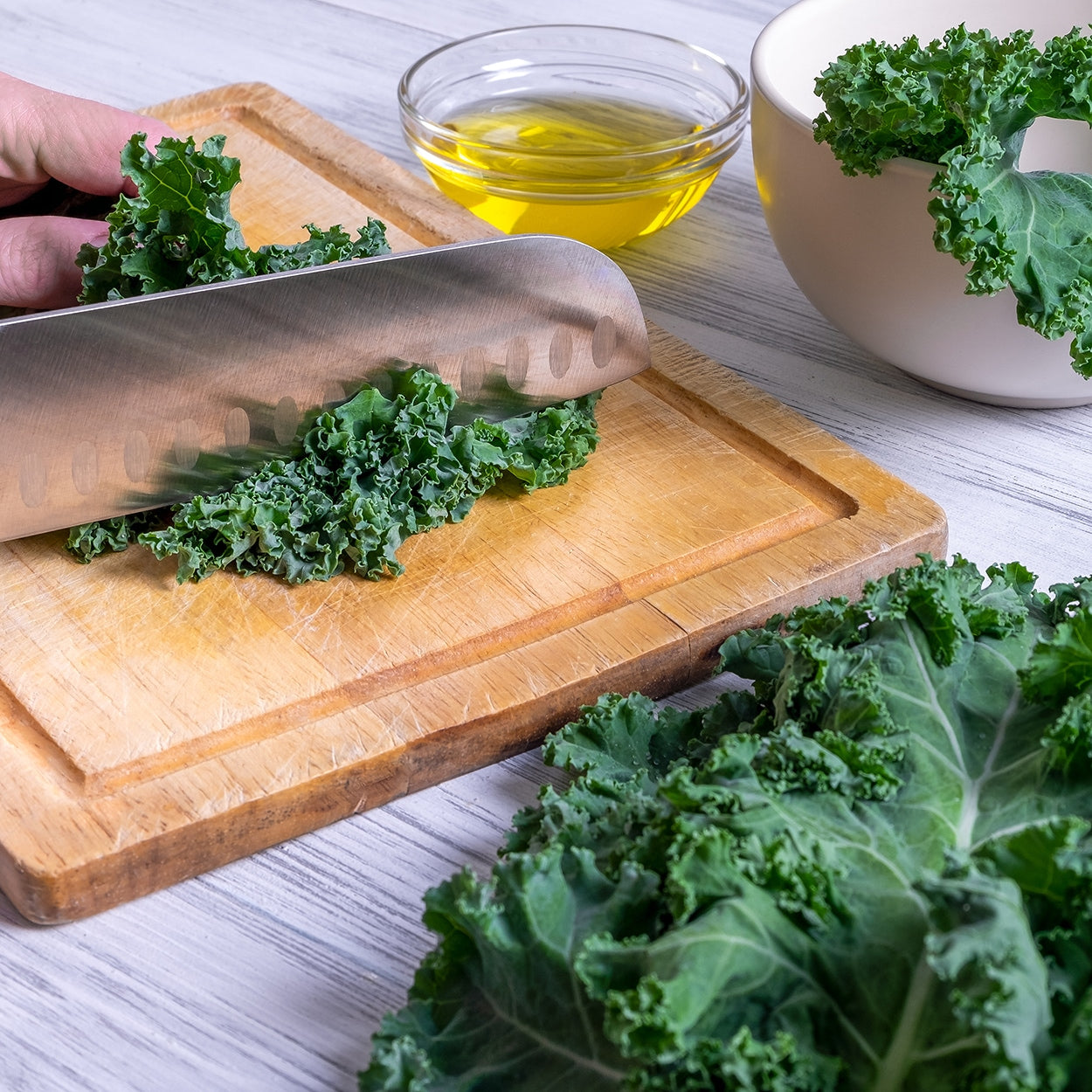 Knife cutting Kale on a cutting board 